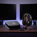 Closed-back studio headphones, matching stand, and soft carrying case arranged on dark wooden desk